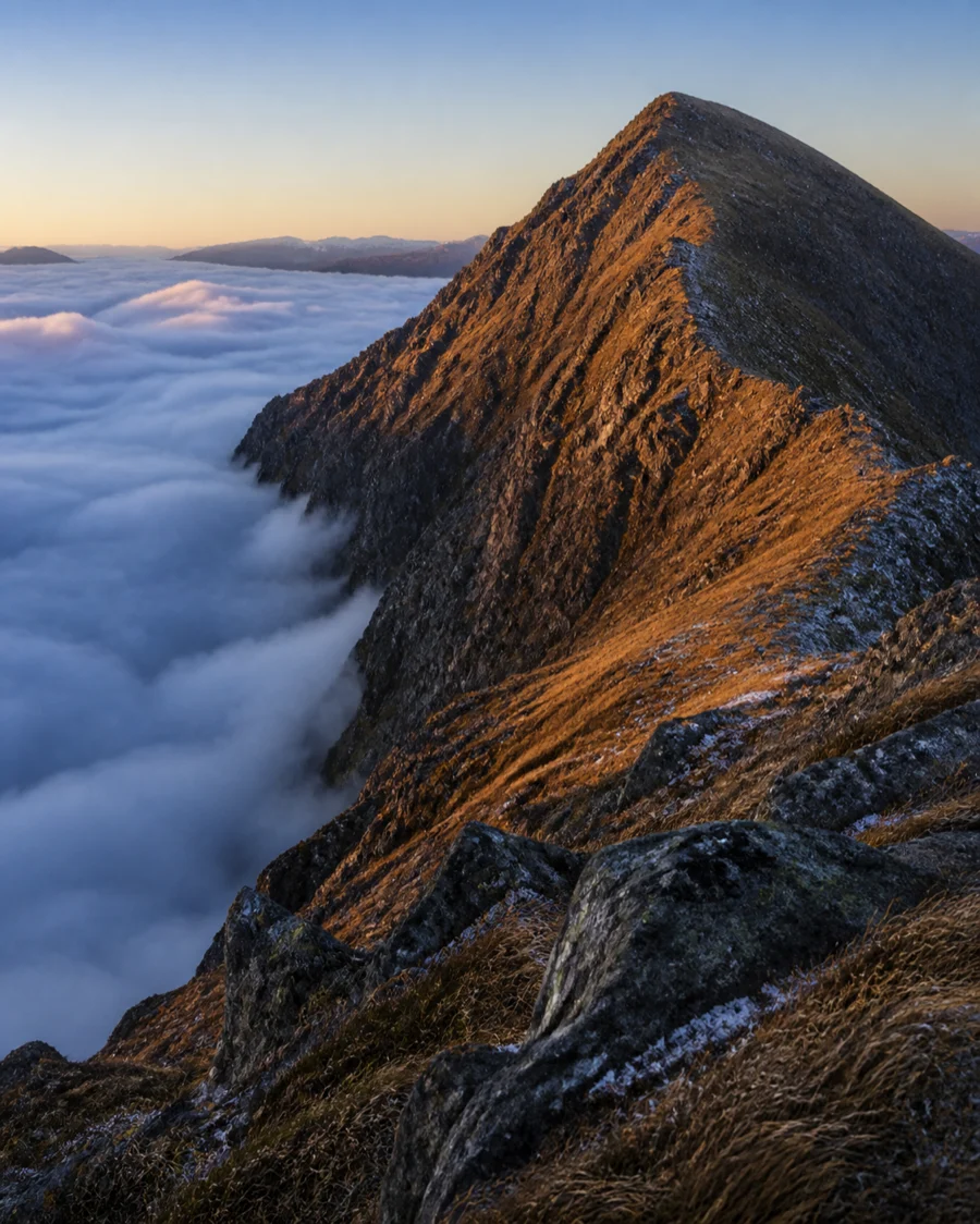 A steep Scottish mountain ridge above a cloud inversion